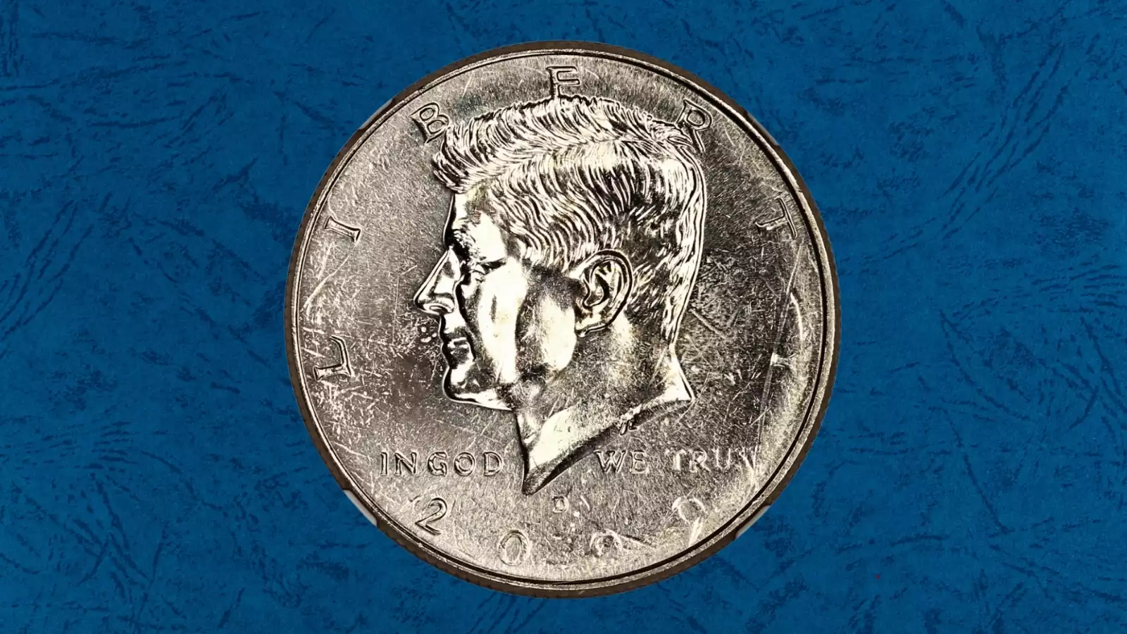 2009 Kennedy half dollar struck-through error showing missing design detail caused by grease-filled die or debris during minting